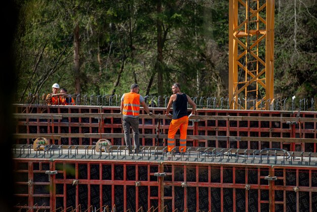 A construction site showing workers building a new bridge with modern equipment, representing the infrastructure projects funded by the plan.