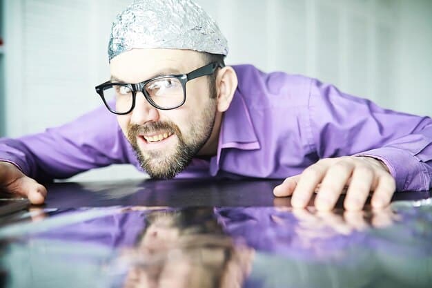 An engineer wearing safety glasses is carefully examining a 3D printed part under a magnifying glass, highlighting the need for quality control and precision in 3D printing processes.