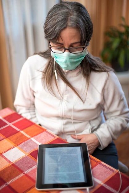 A doctor looking at a tablet displaying data from a patient's wearable device during a remote consultation, demonstrating the use of wearable tech in telehealth.