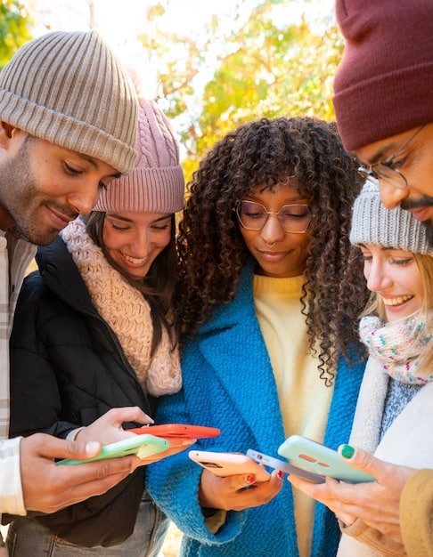A diverse group of people in the US, perhaps from different states, smiling and looking at their phones, some creating short videos, representing the broad and active Snapchat user base.