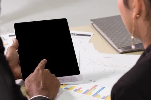 A person reviewing financial charts and projections on a tablet, indicating detailed financial planning in response to tariff changes. Graphs display trend lines affected by new tariffs on imported goods.