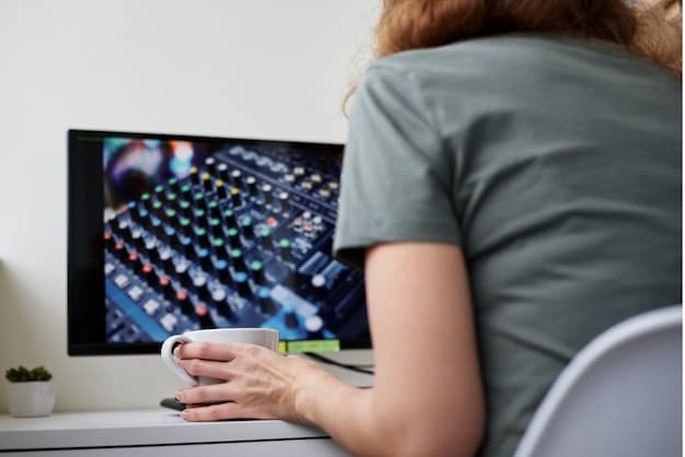 A close-up shot of a music producer using AI software on a computer, with waveforms and algorithmic patterns visible on the screen, illustrating how AI is integrated into the music production process, related to the music industry shakeup: how AI-generated music is changing the game in 2025.